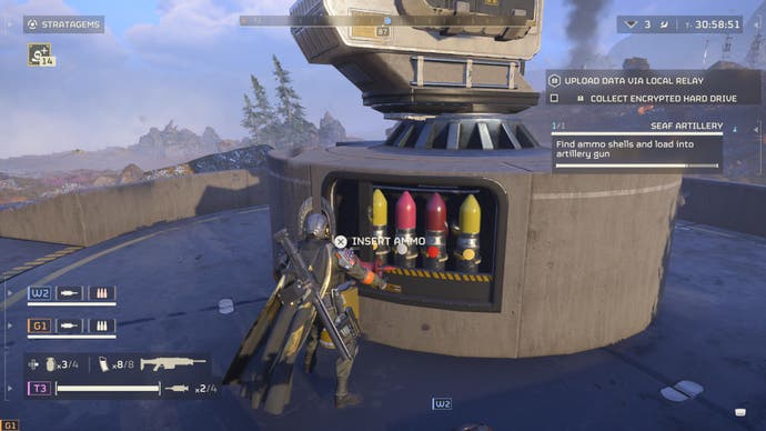 Der Screenshot von Helldivers 2 zeigt den Spieler, der riesige, lippenstiftförmige Munition manuell in ein großes Artilleriegeschütz lädt