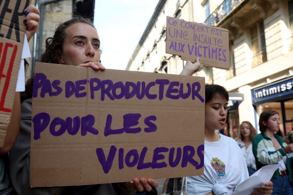 Protesters hold a placard reading "No producers for rapists" during a demonstration outside a theatre in Bordeaux where Gérard Depardieu is due to perform on May 24, 2023.