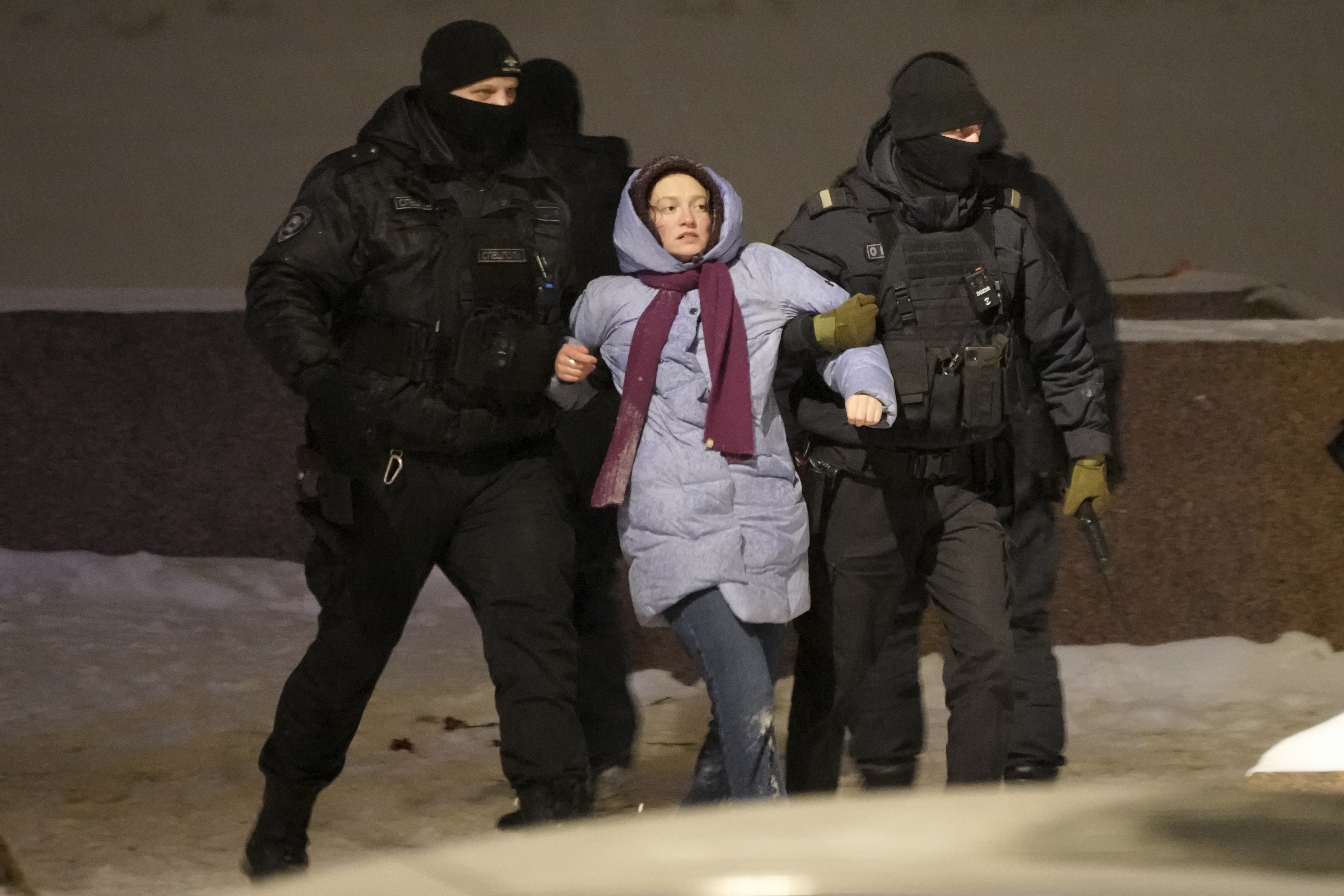 Police officers detain a woman who laid flowers for Alexei Navalny in St. Petersburg, Russia