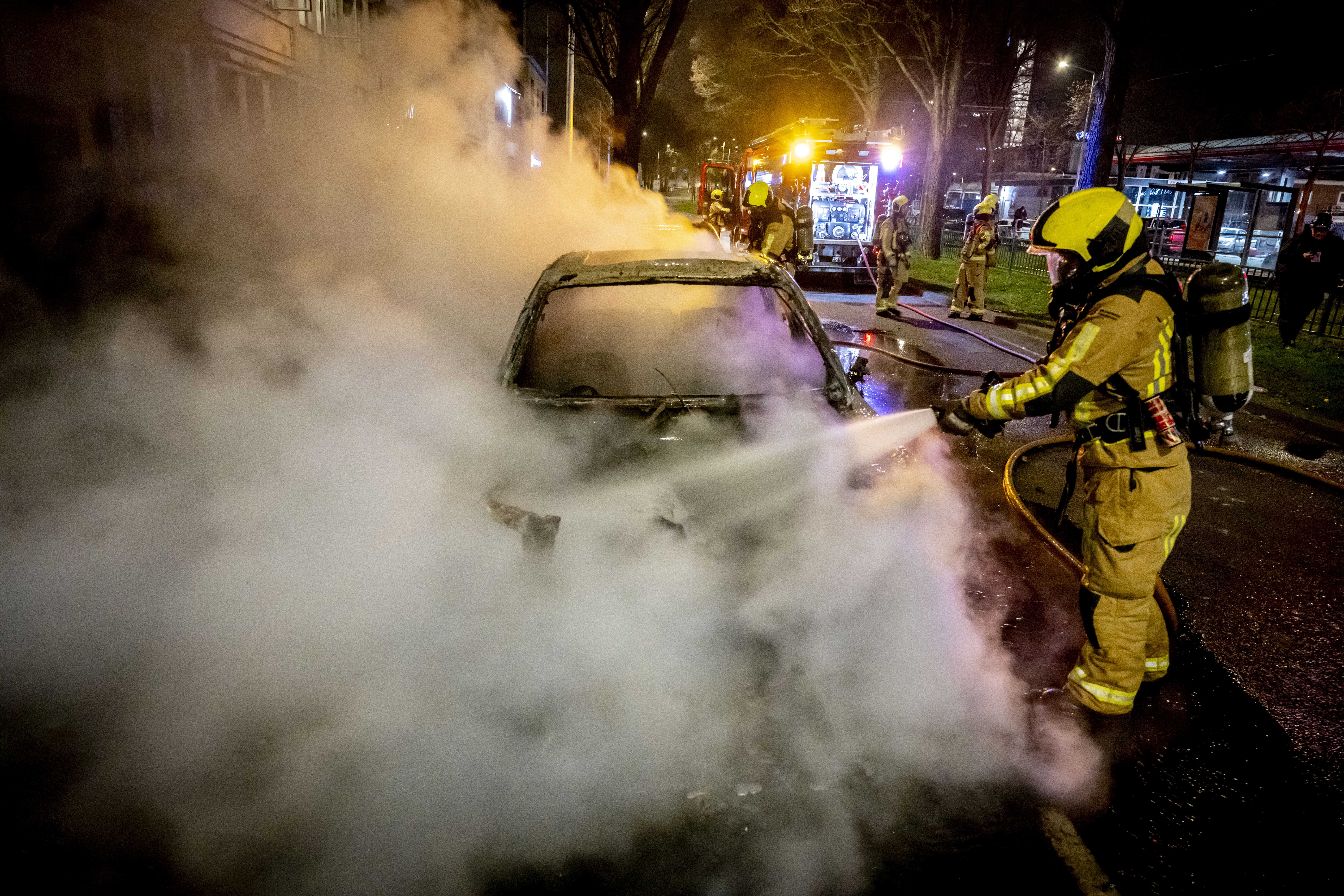 Nach einem Aufstand im Opernhauszentrum versuchen Feuerwehrleute, brennende Polizeiautos zu löschen