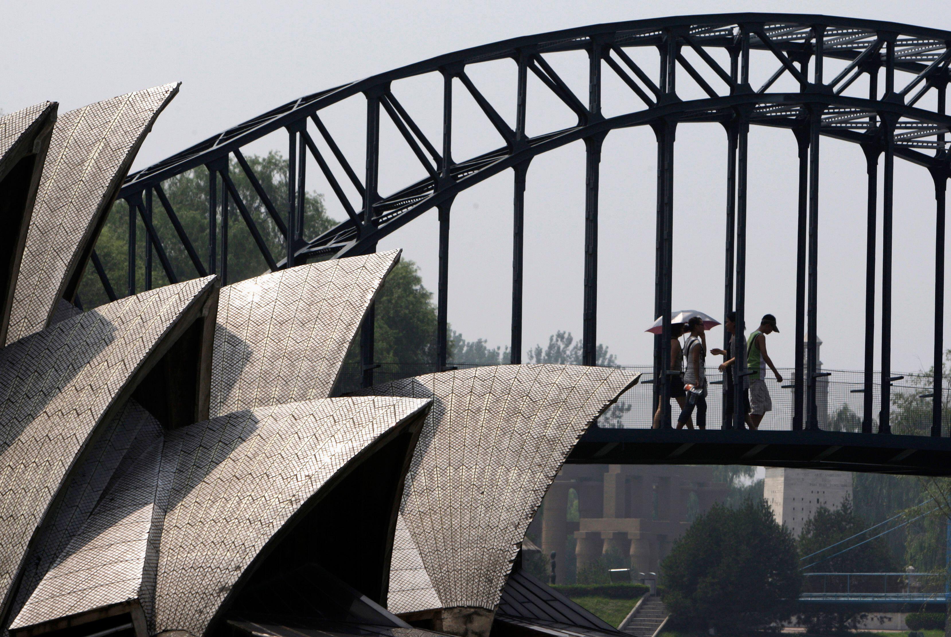 Besucher des Beijing World Park gehen über eine Nachbildung der Sydney Harbour Bridge, die neben einer Nachbildung des Sydney Opera House liegt