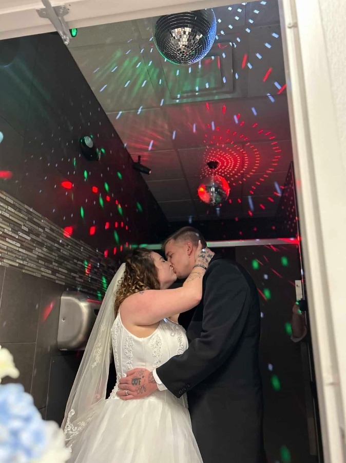 Sie teilten ihren ersten Kuss als Ehepaar unter blinkenden Lichtern