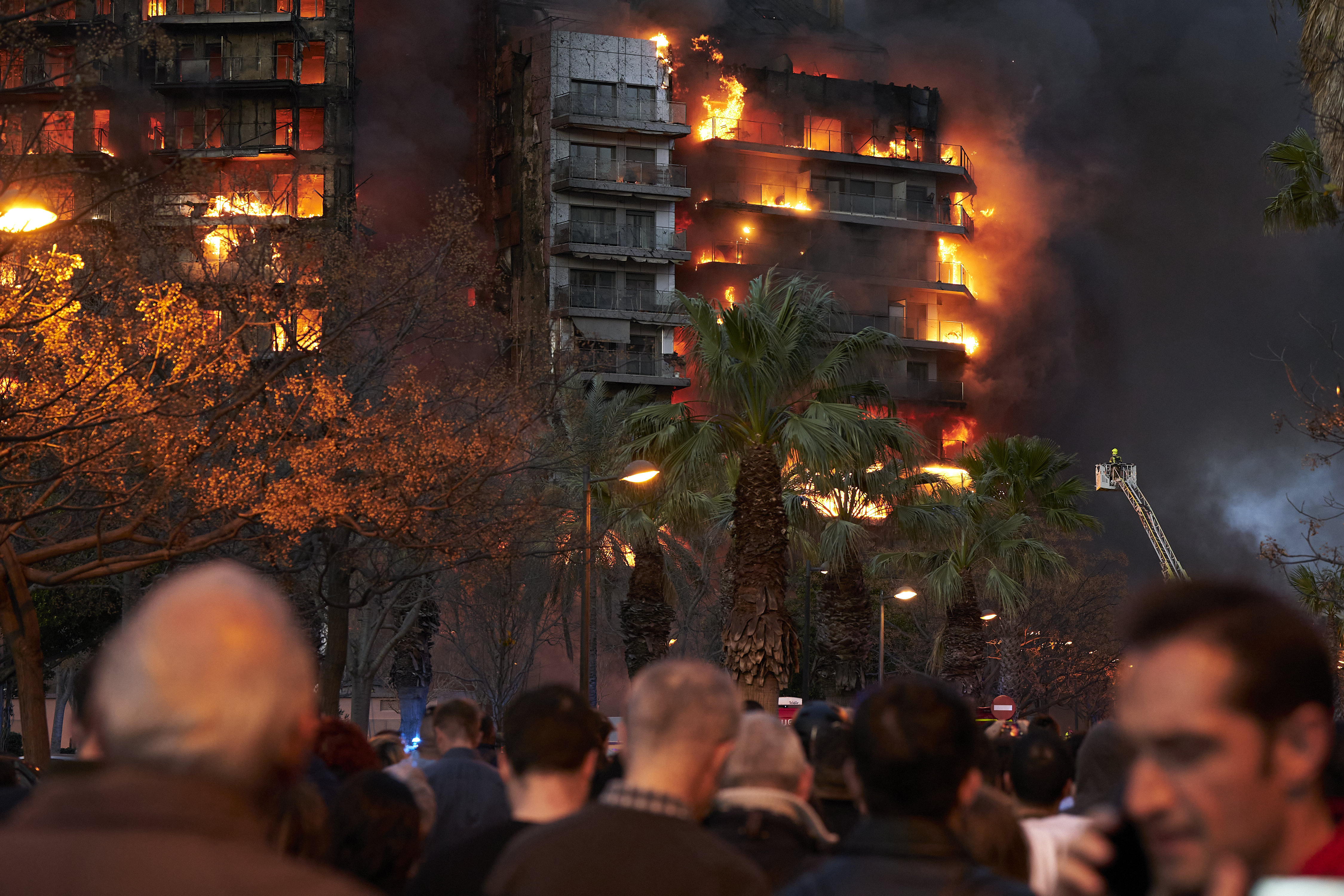 Hunderte Menschen sehen entsetzt den Gebäudebränden zu