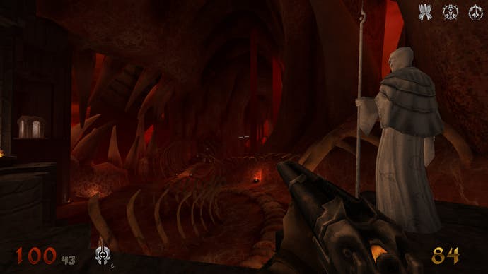 Ein Screenshot von Wrath: Aeon of Ruin, der den Spieler in einem großen Hubbereich aus Fleisch und Knochen zeigt, wie er neben einer weißen, kahlköpfigen Gestalt steht, die einen Stab hält.