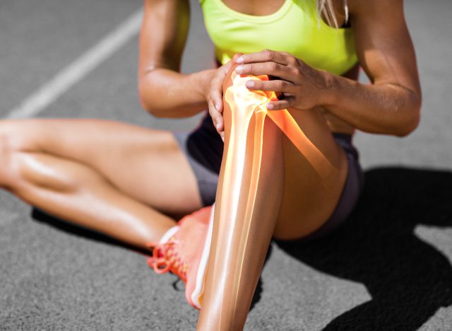 Frau mit Beinverletzung und Schmerzen, weil sie sich vor dem Training nicht aufwärmt