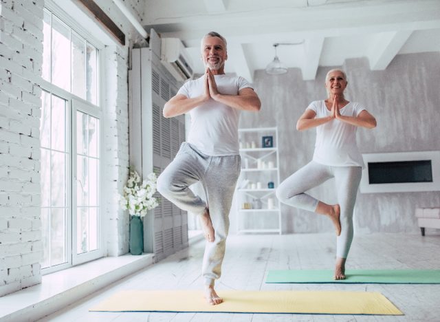 Älteres Paar macht zu Hause ausgleichende Yoga-Übungen