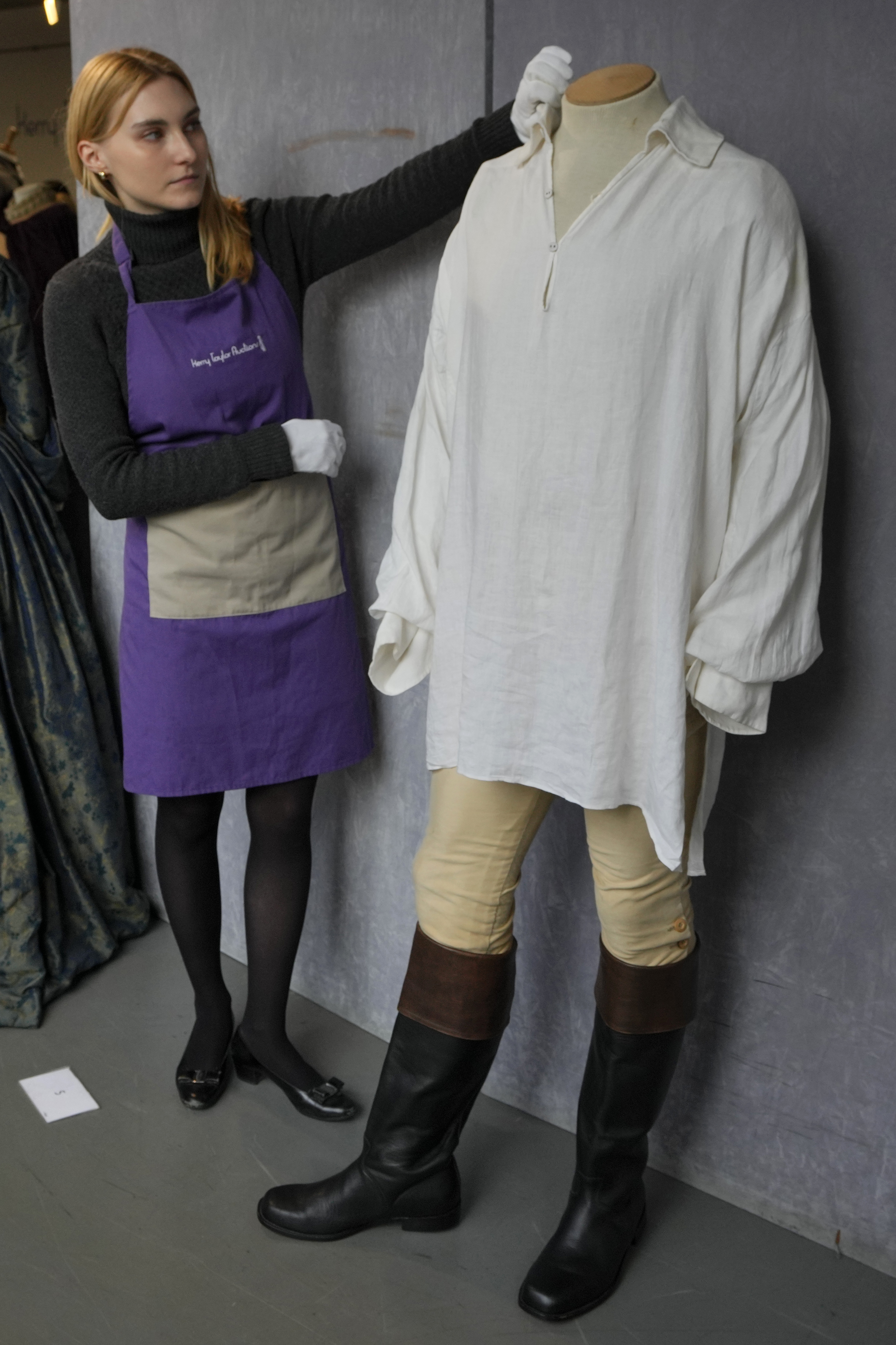 Ein Kostümbildner arrangiert Colin Firths „Wet-Shirt“-Kostüm als Mr. Darcy in der Fernsehserie Pride and Prejudice bei Kerry Taylor Auctions in London
