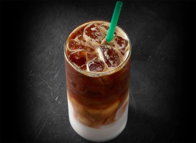 Starbucks Blonde Vanilla Latte in einem Glas auf einem schlichten Hintergrund.