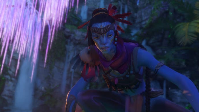 Avatar: Frontiers of Pandora-Screenshot, der zeigt, wie ein wunderschöner, in Lila gekleideter Na'vi nach unten auf etwas blickt, das wir nicht sehen können.  Links von ihr leuchtet ein fluoreszierender Baum.