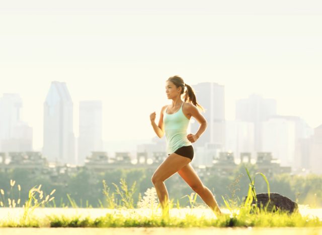 Fitte Frau läuft draußen im sonnigen Park, Konzept der einfachsten Übungen zur Gewichtsabnahme