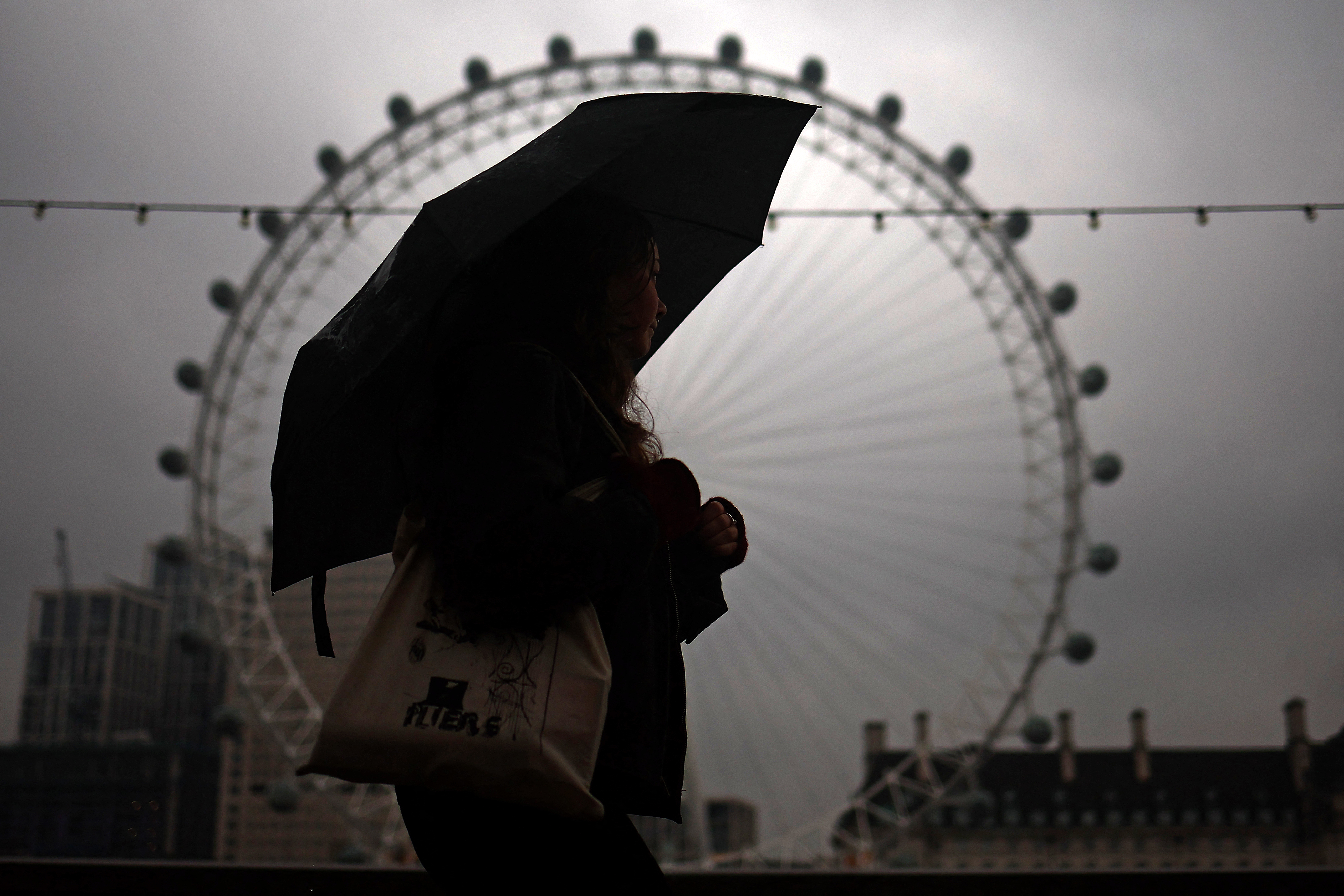 Ein Fußgänger schützt sich unter einem Regenschirm vor dem Regen
