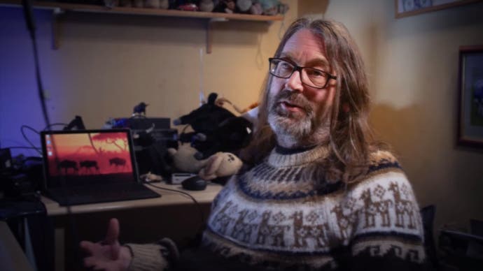 Jeff Minter trägt einen Pullover und spricht in die Kamera in „Llamasoft: The Jeff Minter Story“.