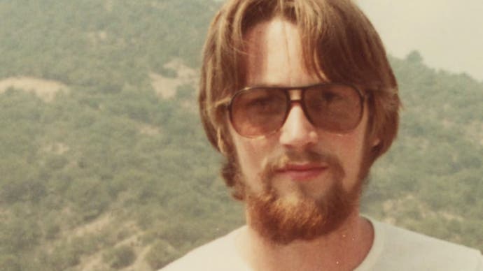 Ein Foto von Jeff Minter als junger Mann, mit Sonnenbrille und Bart.  Die Vergilbung des Fotos lässt auf die 70er oder frühen 80er Jahre schließen.  Von Llamasoft: Die Jeff Minter Story