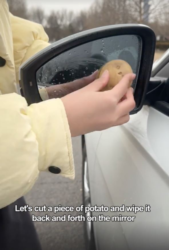 Sie reinigt verschiedene Teile des Autos mit einer Kartoffel