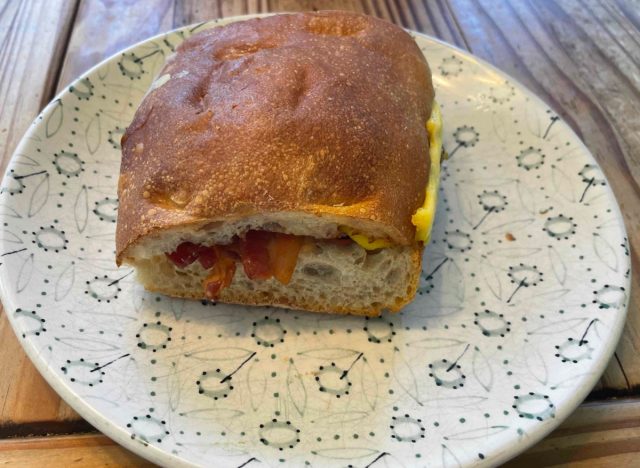 Panera-Speck-Ei und Käse auf Ciabatta-Sandwich auf bedrucktem Teller.