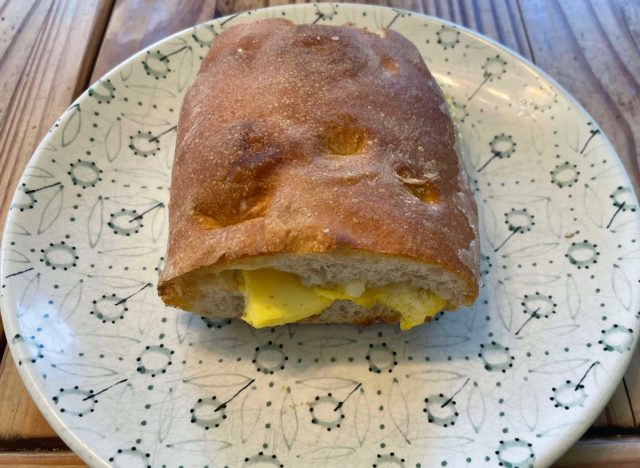 Panera-Ei und Käse auf Ciabatta-Sandwich auf einem bedruckten Teller.