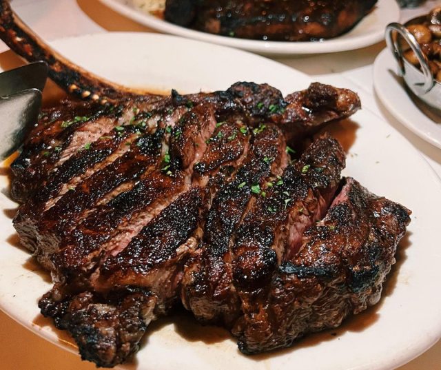 Ribeye-Steak mit Knochen, in Scheiben geschnitten und ordentlich angerichtet im Morton's the Steakhouse