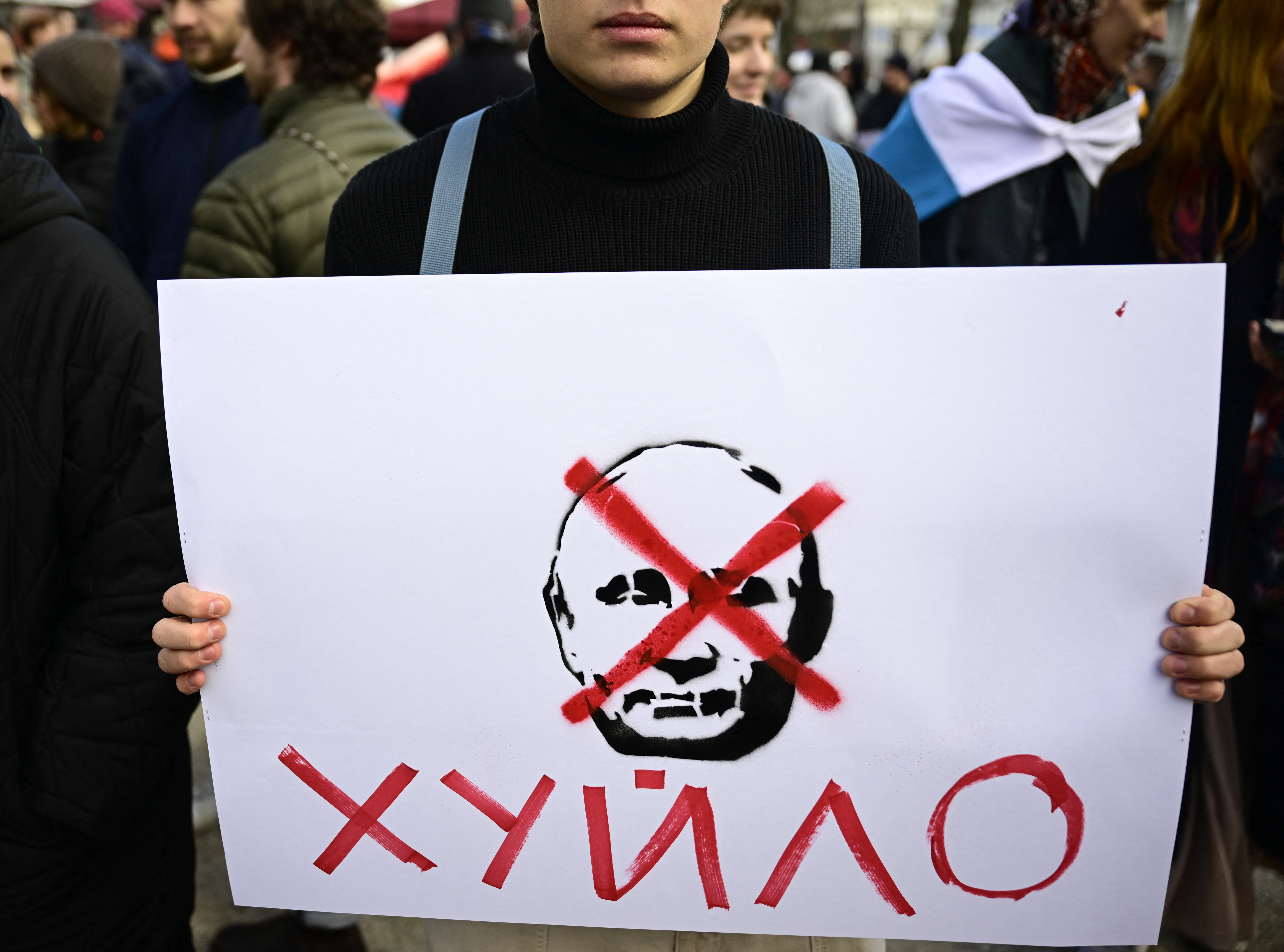 Ein Demonstrant hält ein Schild mit einem durchgestrichenen Putin