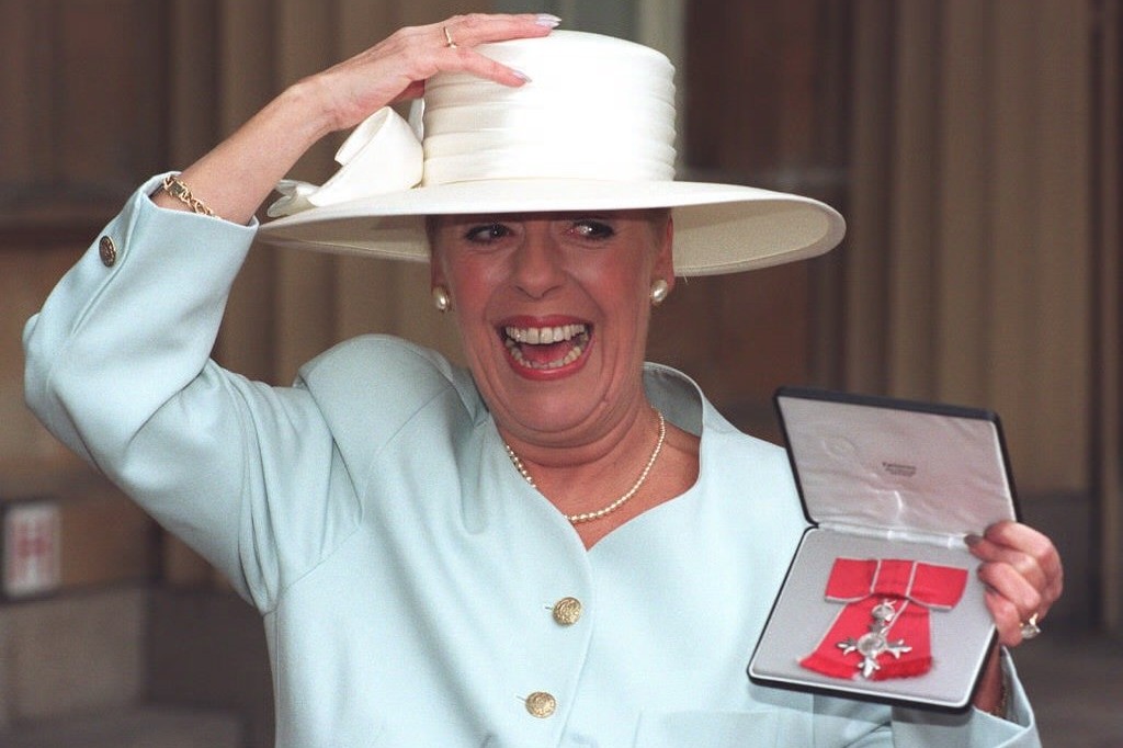 Julie erhielt 1996 einen MBE für Verdienste um die Schauspielerei. Im Bild vor dem Buckingham Palace