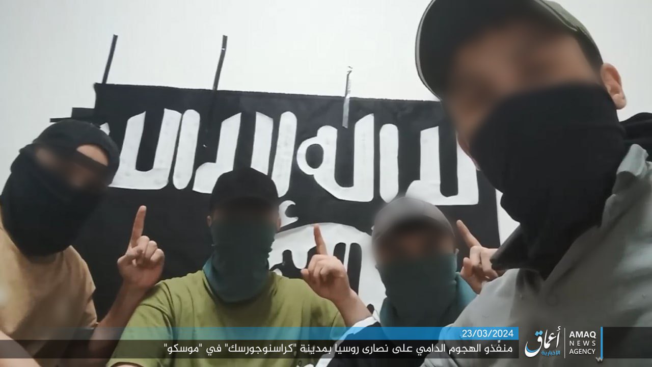 ISIS veröffentlichte ein angebliches Bild der vier bewaffneten Männer, die vor dem Angriff mit ihrer schwarzen Todeskultfahne posierten