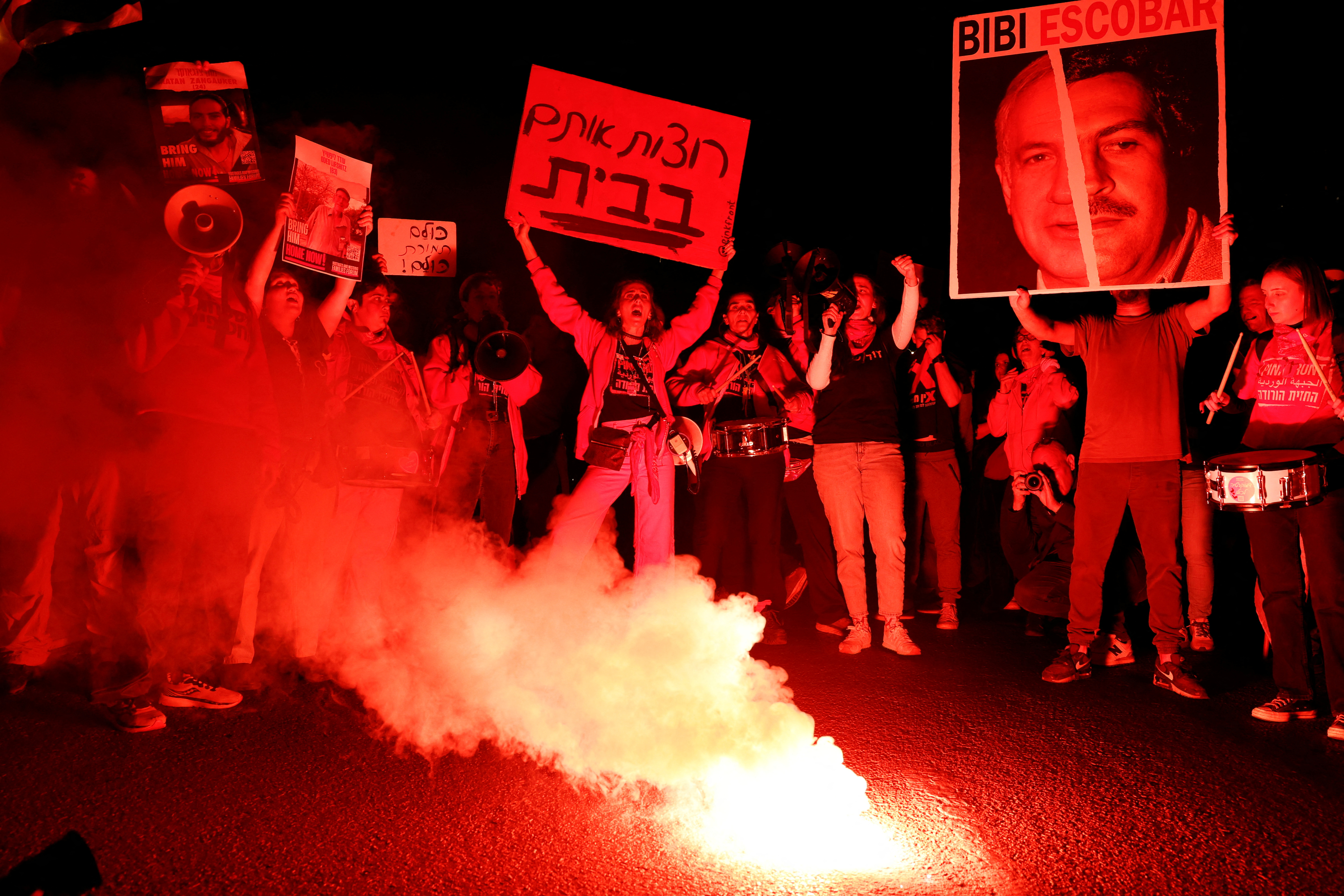 Israelis stehen während einer Protestaktion gegen den israelischen Premierminister am 23. März neben einem Lagerfeuer