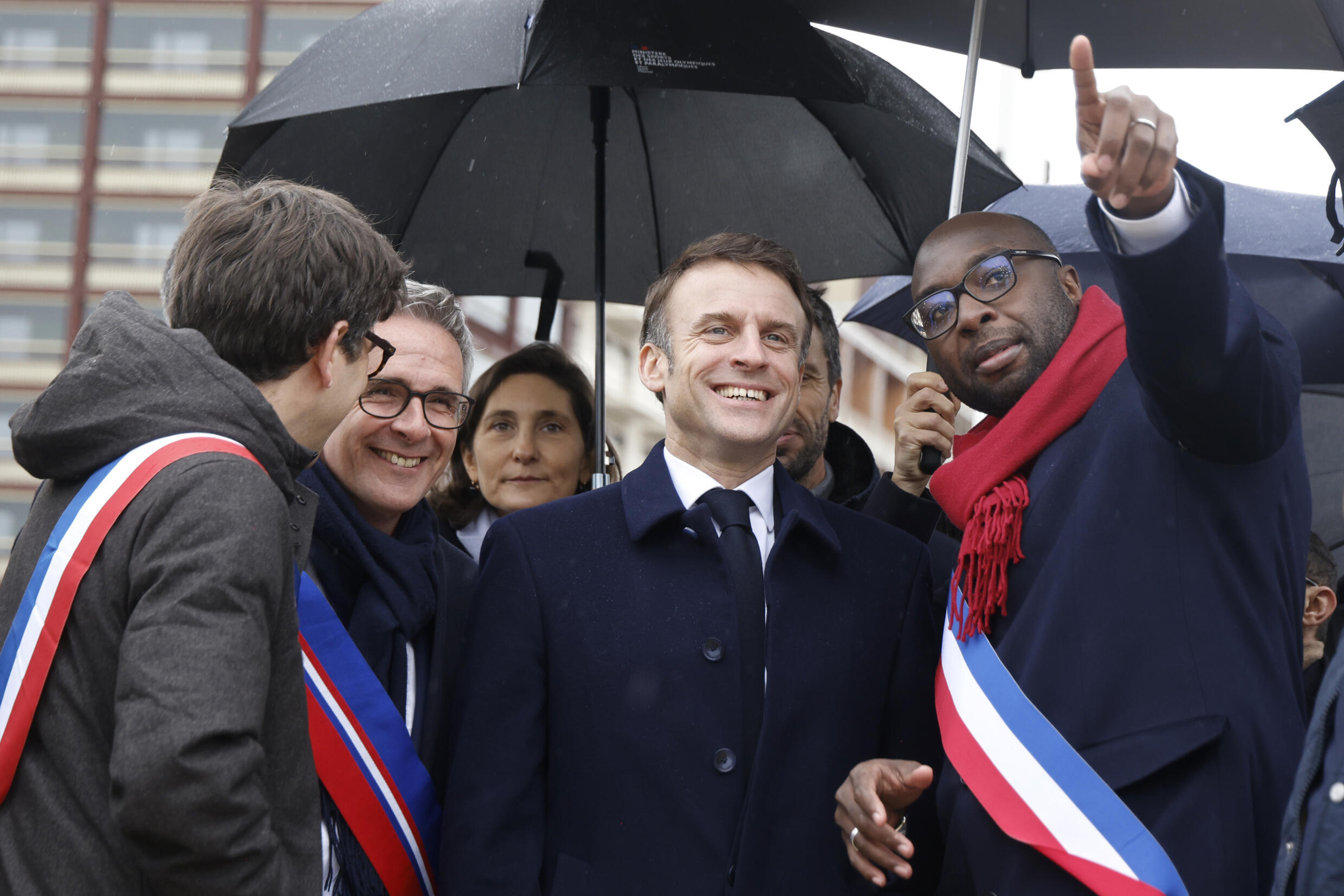 Mohamed Gnabaly (r.), der Bürgermeister von Ile-Saint-Denis, führt den französischen Präsidenten Emmanuel Macron durch das Olympische Dorf.