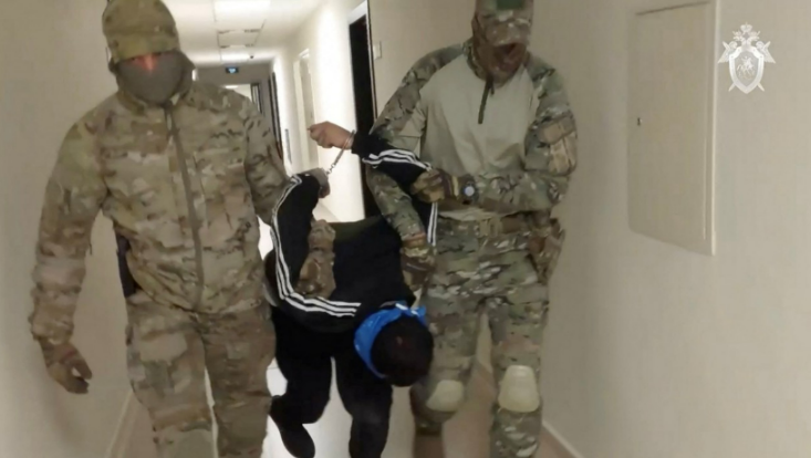 Maskierte Beamte zogen einen Verdächtigen aggressiv durch die Korridore des russischen Ermittlungsausschusses