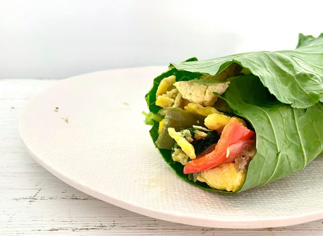 Whole30-Frühstücks-Burrito auf einem weißen Teller, eingewickelt in Grünkohl