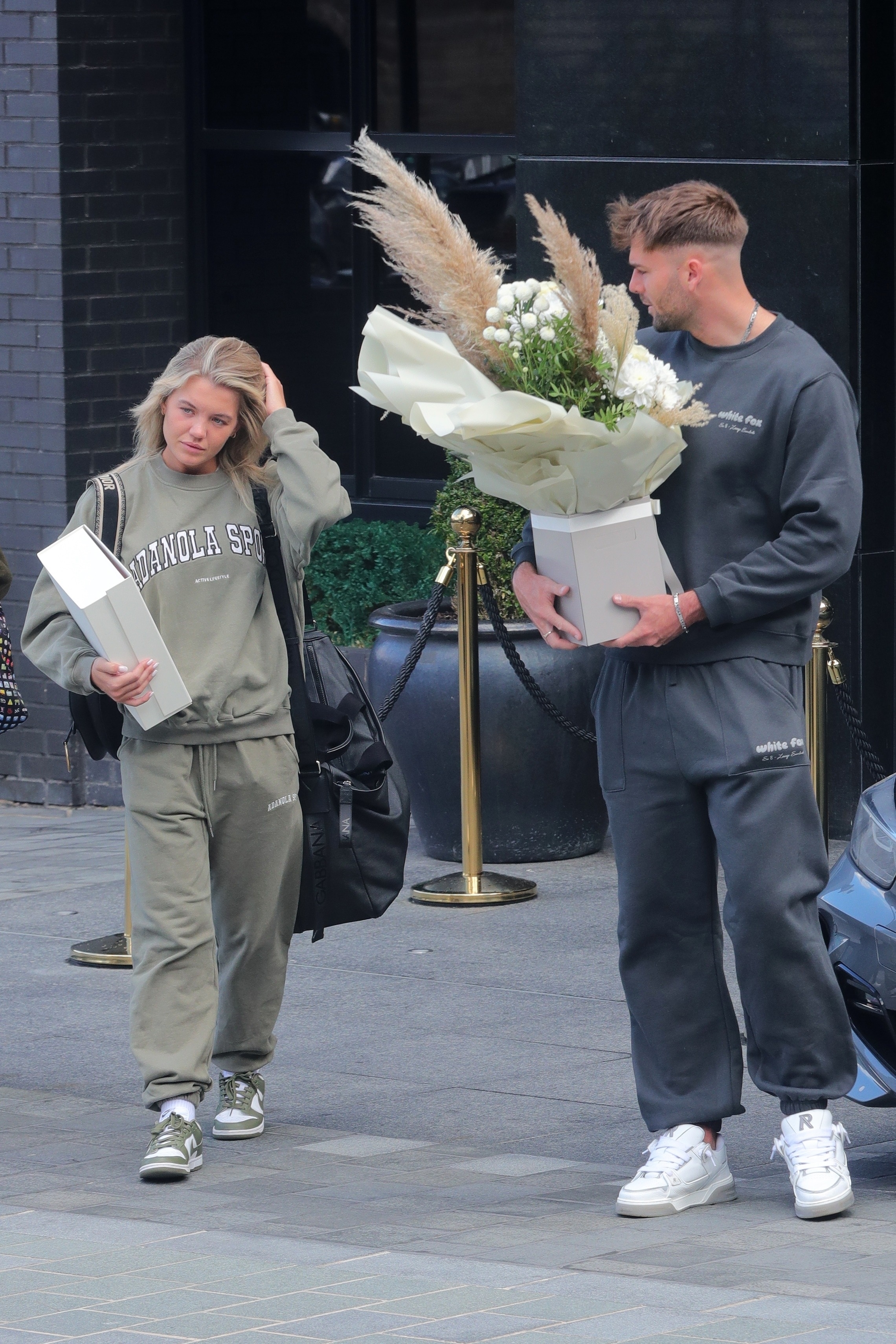 Ihr Freund Tom Clare, 24, musste die Blumen tragen, als sie ihr Hotel in Manchester verließen