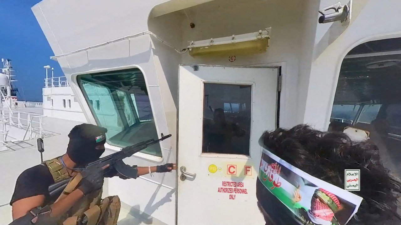Houthi-Kämpfer öffnen die Tür zur Brücke auf einem Schiffsdeck im Roten Meer