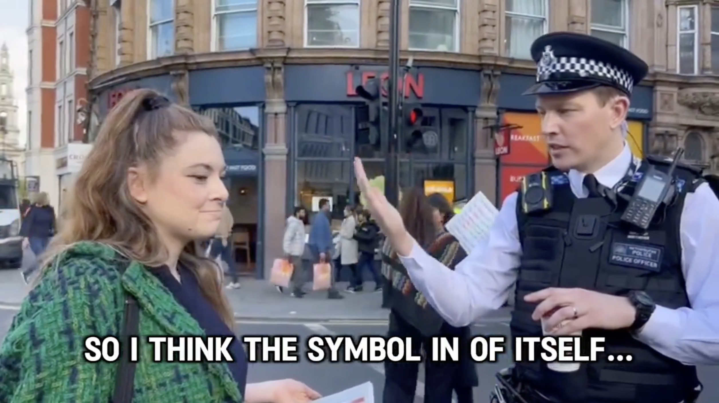 Man sieht eine verzweifelte jüdische Frau, die sich über das Nazi-Symbol auf Plakaten beschwert