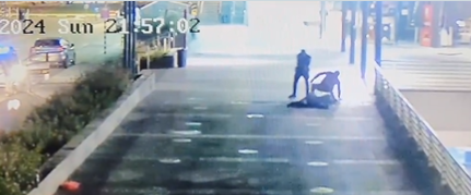 Er schießt auf den Angreifer, der zu Boden fällt, während der andere Polizist herausklettert