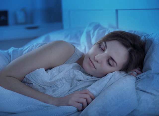 Frau schläft nachts friedlich im Bett, nachdem sie die betrunkene Affenübung für besseren Schlaf gemacht hat