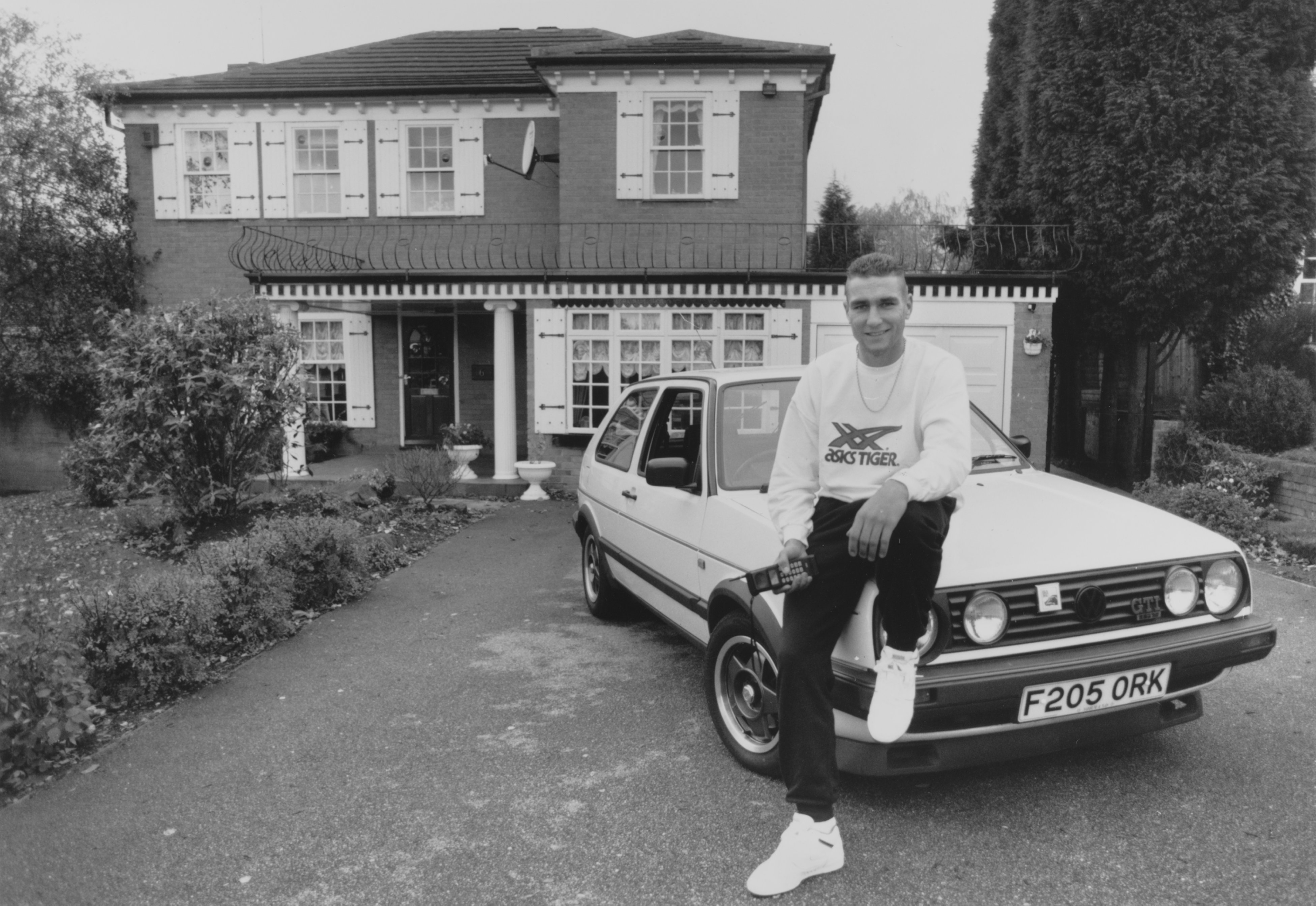 Vinnie Jones vor seinem Haus in Leeds mit seinem Golf GTI im Jahr 1990