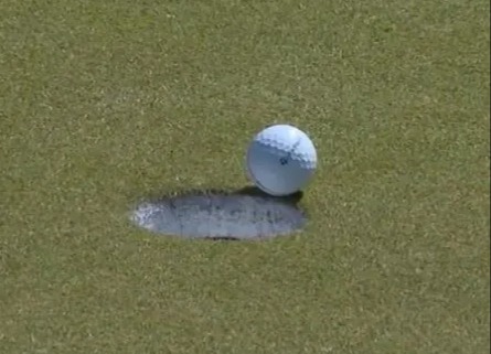 Der Golfspieler blieb auf dem Grün stehen und wartete darauf, dass sein Ball ins Loch fiel