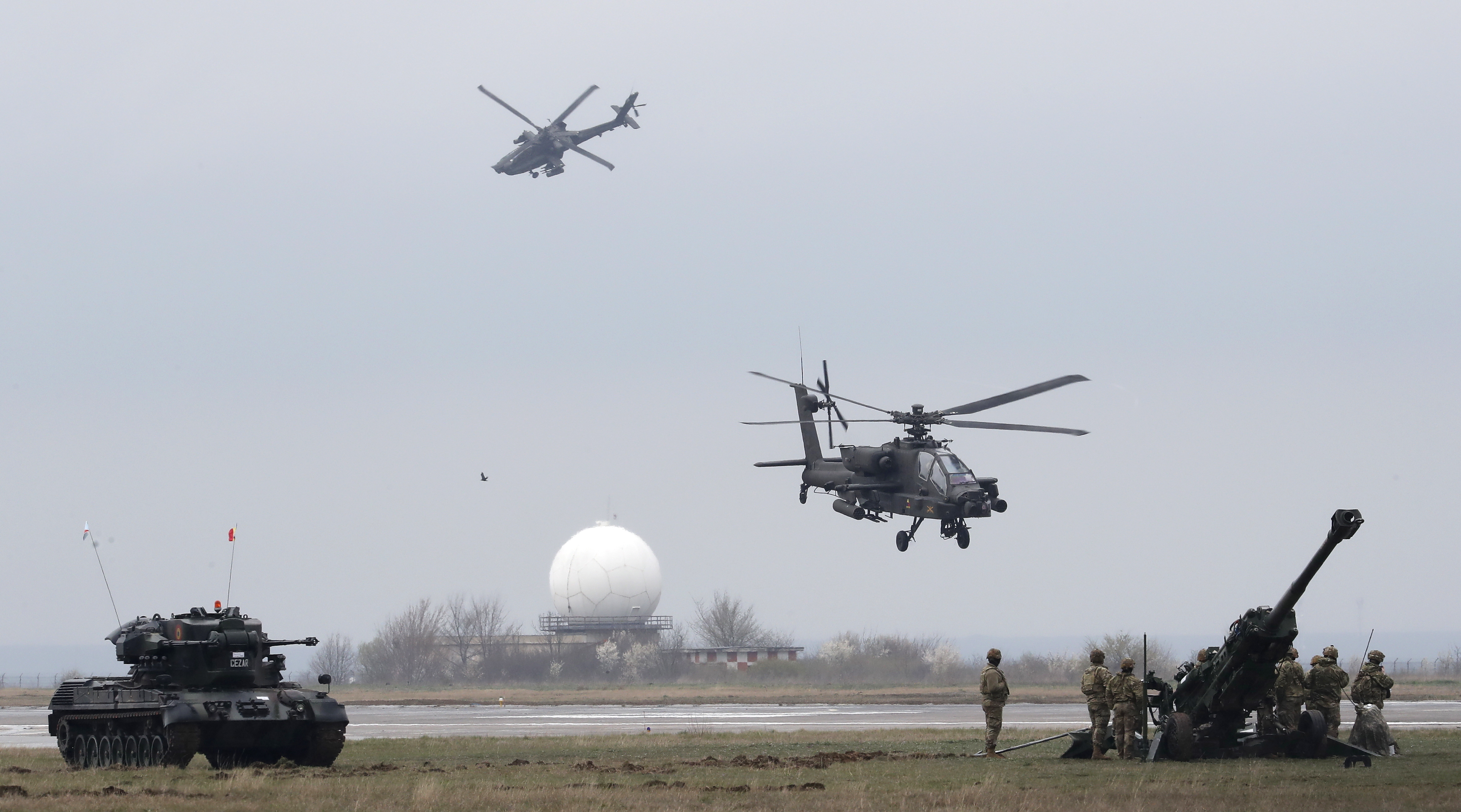 Two US Apache helicopters and land forces in action during Nato exercises in Romania