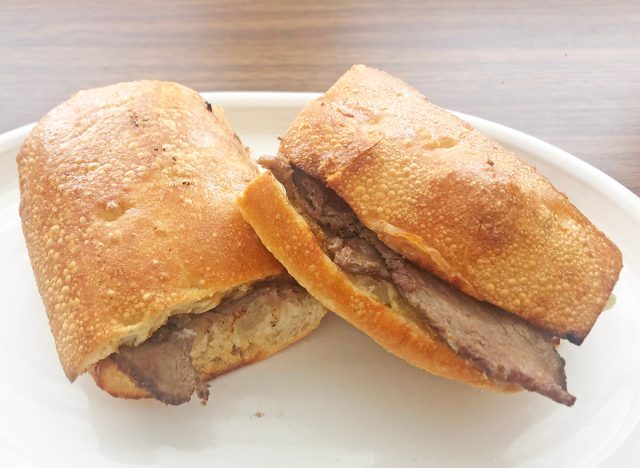 Ein Panera-Cheesesteak-Sandwich, halbiert auf einem weißen Teller.