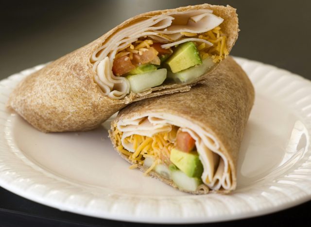 Truthahn-Cheddar-Avocado-Wrap auf weißem Teller