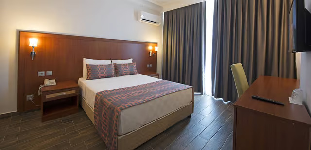 Jedes Zimmer im Sunbay Park Hotel verfügt über einen Fernseher, einen Minikühlschrank, eine Klimaanlage und eine Terrasse oder einen Balkon