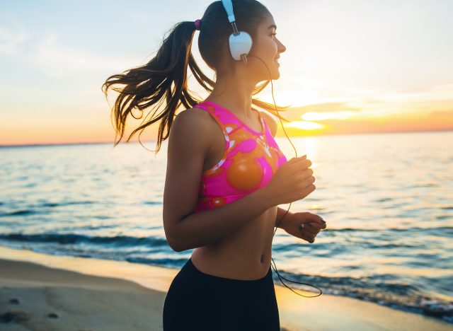 Eine Fitnessfrau, die am Strand joggt, demonstriert die Vorteile von 10 Minuten Joggen am Tag