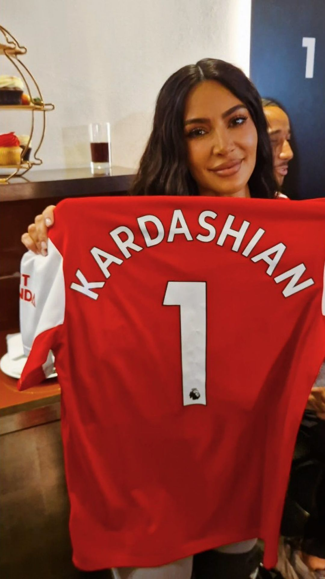 Kim Kardashian posiert mit einem Gunners-Top