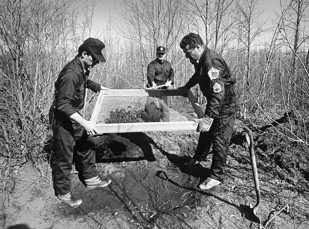 Criminal investigators search for bodies along the Knik River in Alaska in April 1984