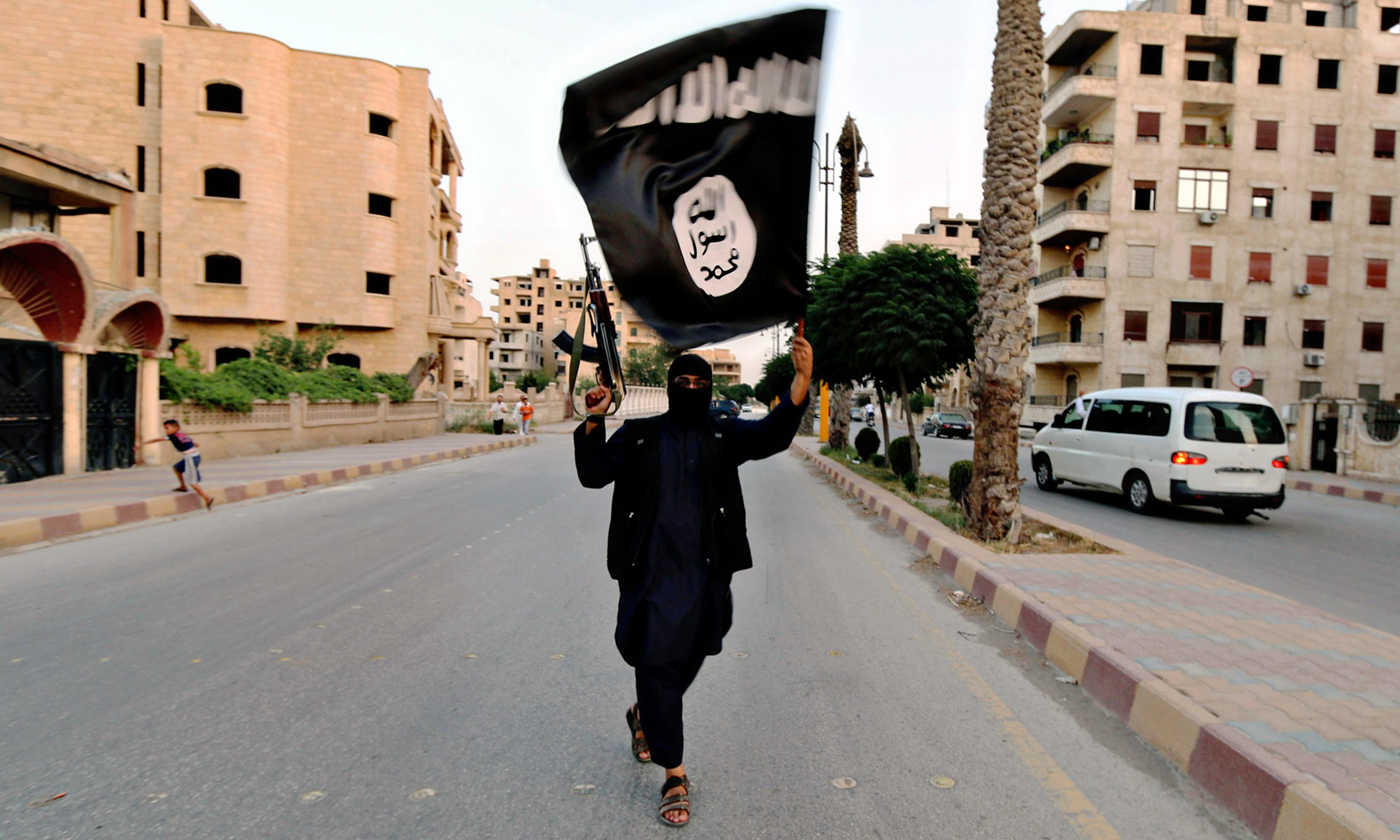 Ein einsamer IS-Terrorist schwenkt während einer Militärparade in Syrien eine schwarze Flagge