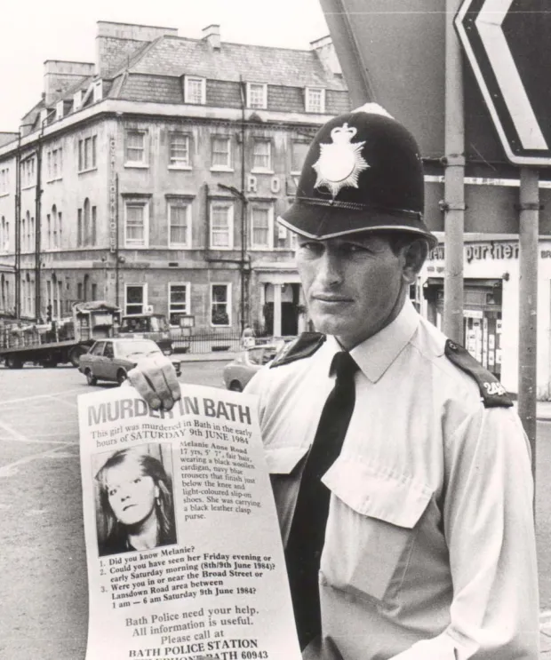 Ein Polizist hält ein Plakat in der Hand, auf dem er um Hilfe bei der Suche nach dem Mörder des Teenagers bittet
