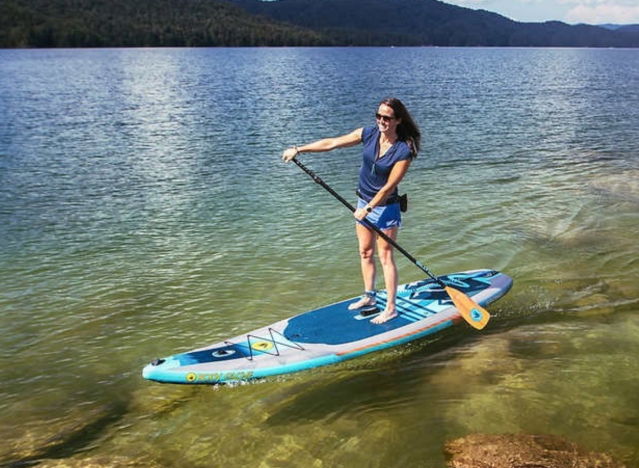 eine Frau, die ein Paddle-Board benutzt.