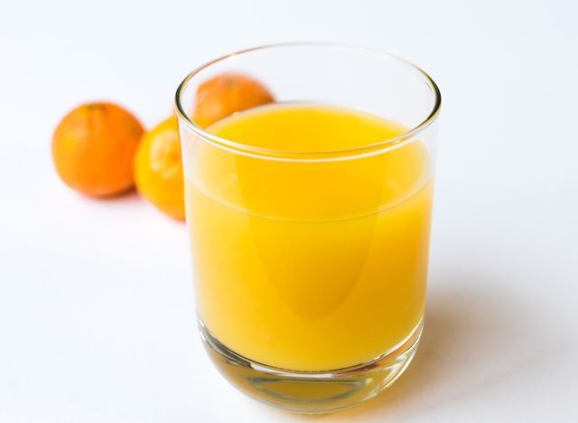 Glas Orangensaft mit Orangen