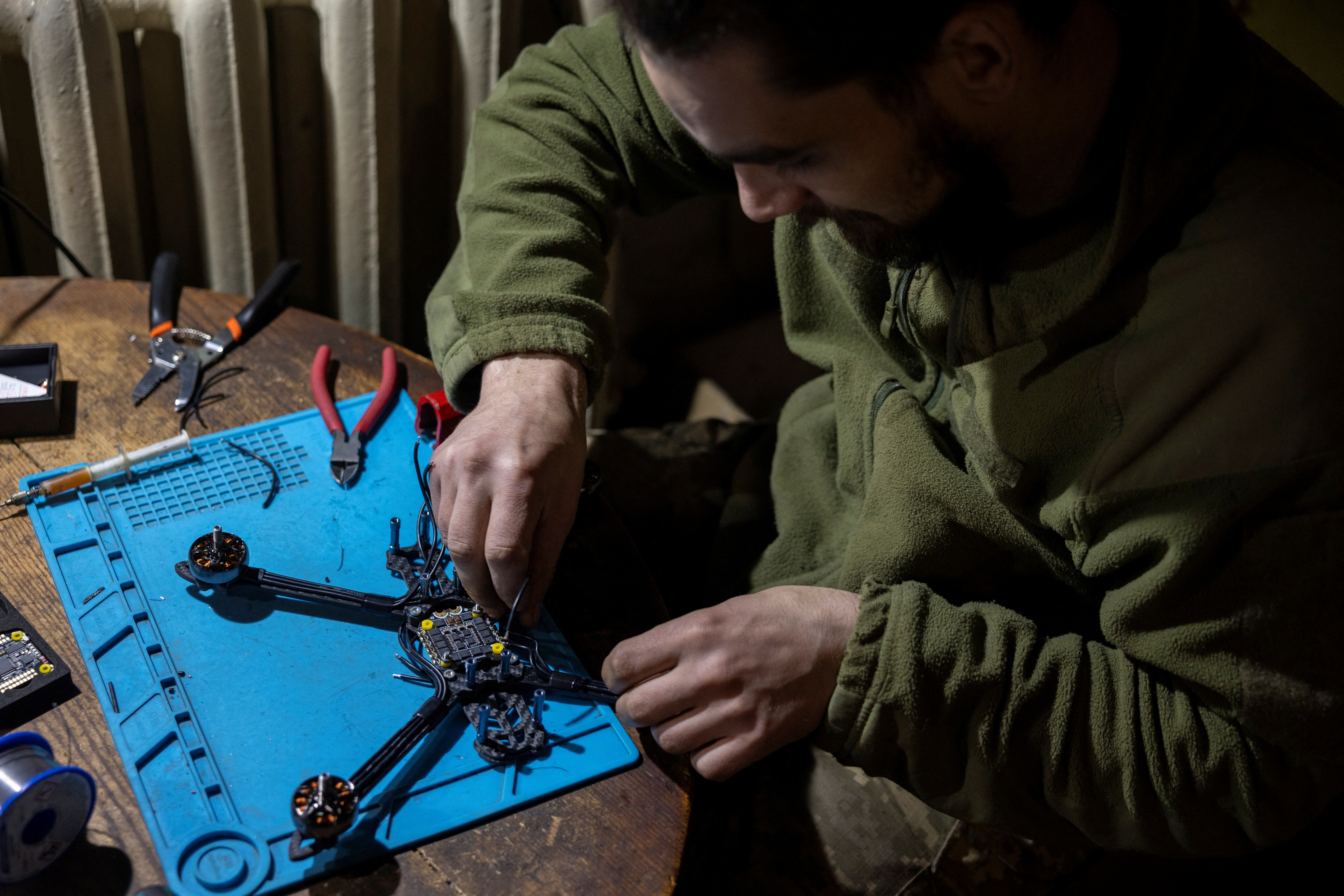 Ein Spezialsoldat ist dabei zu sehen, wie er nahe der Frontlinie eine Drohne zusammenbaut – doch Zivilisten helfen jetzt von zu Hause aus beim Bau der UAVs