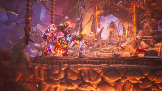 Tales of Kenzera-Screenshot, der die Hauptfigur gegen einen riesigen maskierten Boss in einer feurigen Höhle zeigt