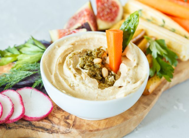 Schüssel Hummus mit Gemüse an Bord, Konzept der besten 100-Kalorien-Snacks zur Gewichtsreduktion