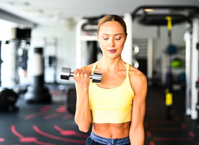 Durchtrainierte Frau beim Gewichtheben, Konzept der 4-1-1-Trainingsmethode für den Fettabbau
